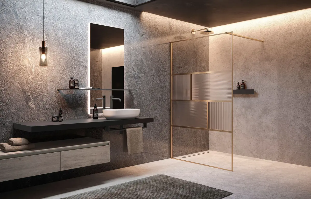 Baño de piedra gris con mampara de ducha Novellini de perfil dorado y mueble suspendido con lavabo blanco